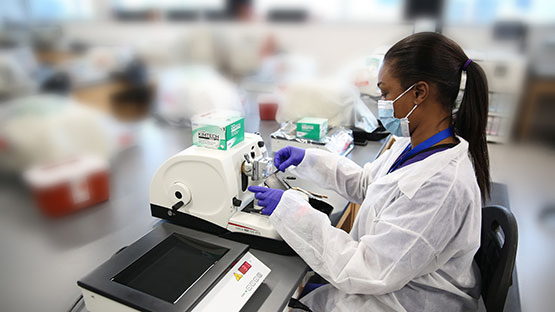 Woman in a lab coat processing a sample