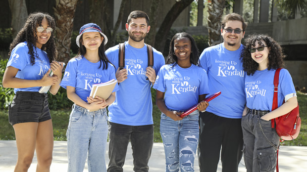 Group of students with blue shirts stand together