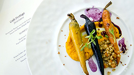 Plate of carrots in a sauce with a menu under the plate