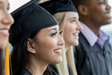 Asian female student stands with other graduates