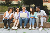 Group of students crowded around a laptop